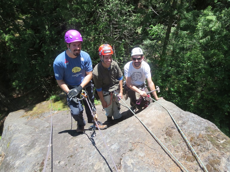Three men work hard building a rock climbing route in Ymir, British Columbia